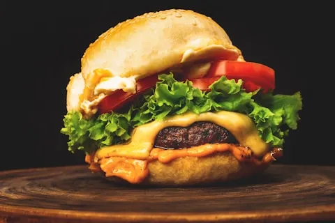 Cheeseburger with lettuce and tomato on a wooden board