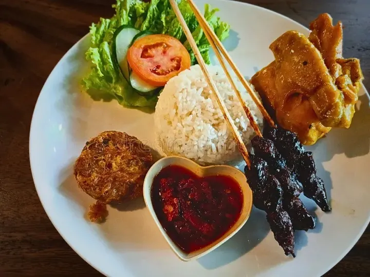 Rice, tofu, salad and satay skewers with a bowl of chilli sauce