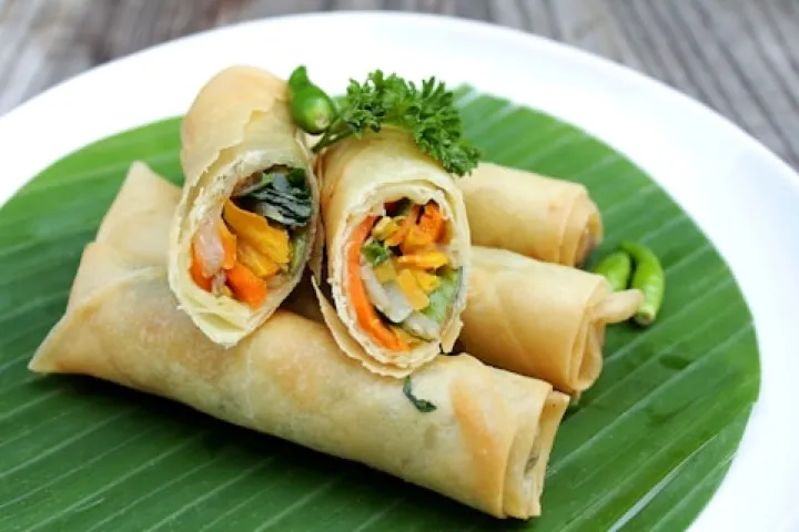 Sliced vegetable spring rolls on a banana leaf